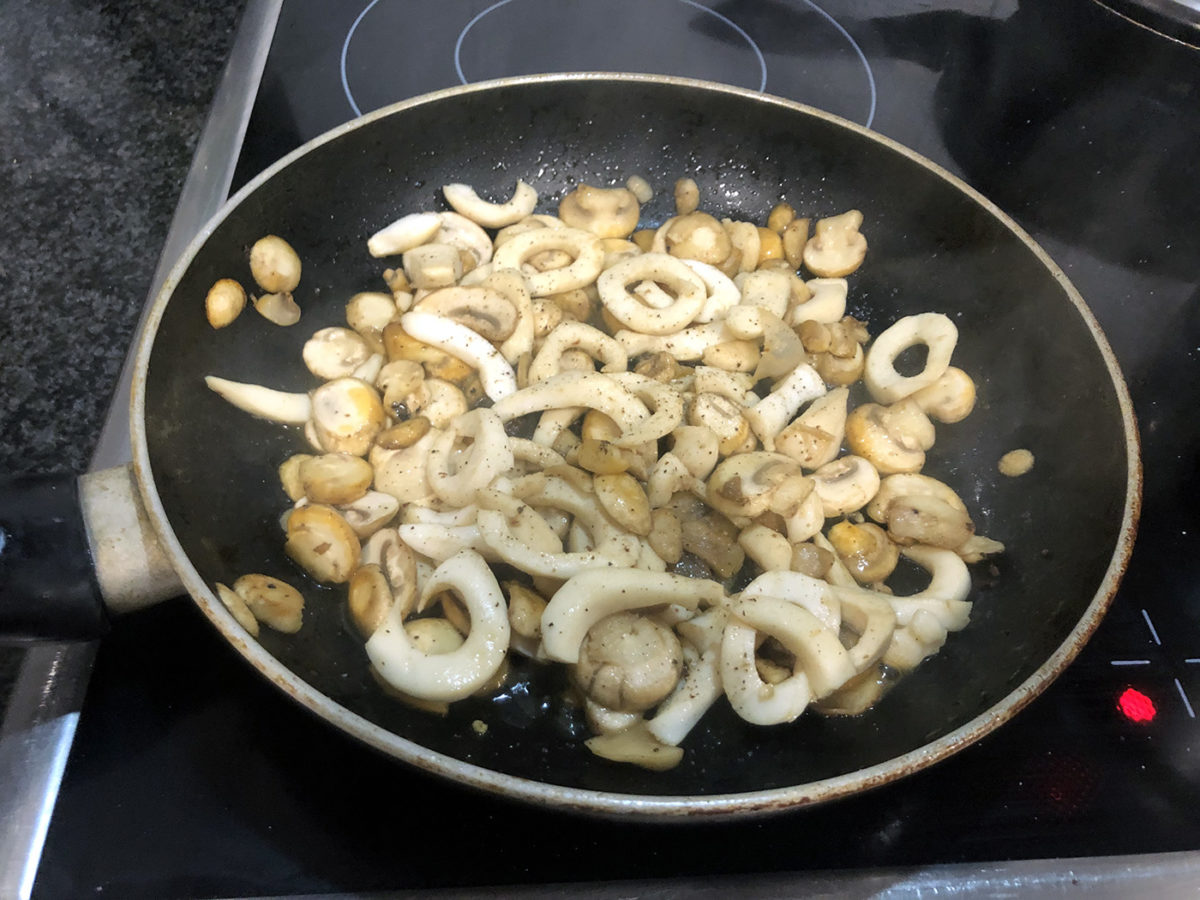 Готовые кальмары с грибами на сковороде